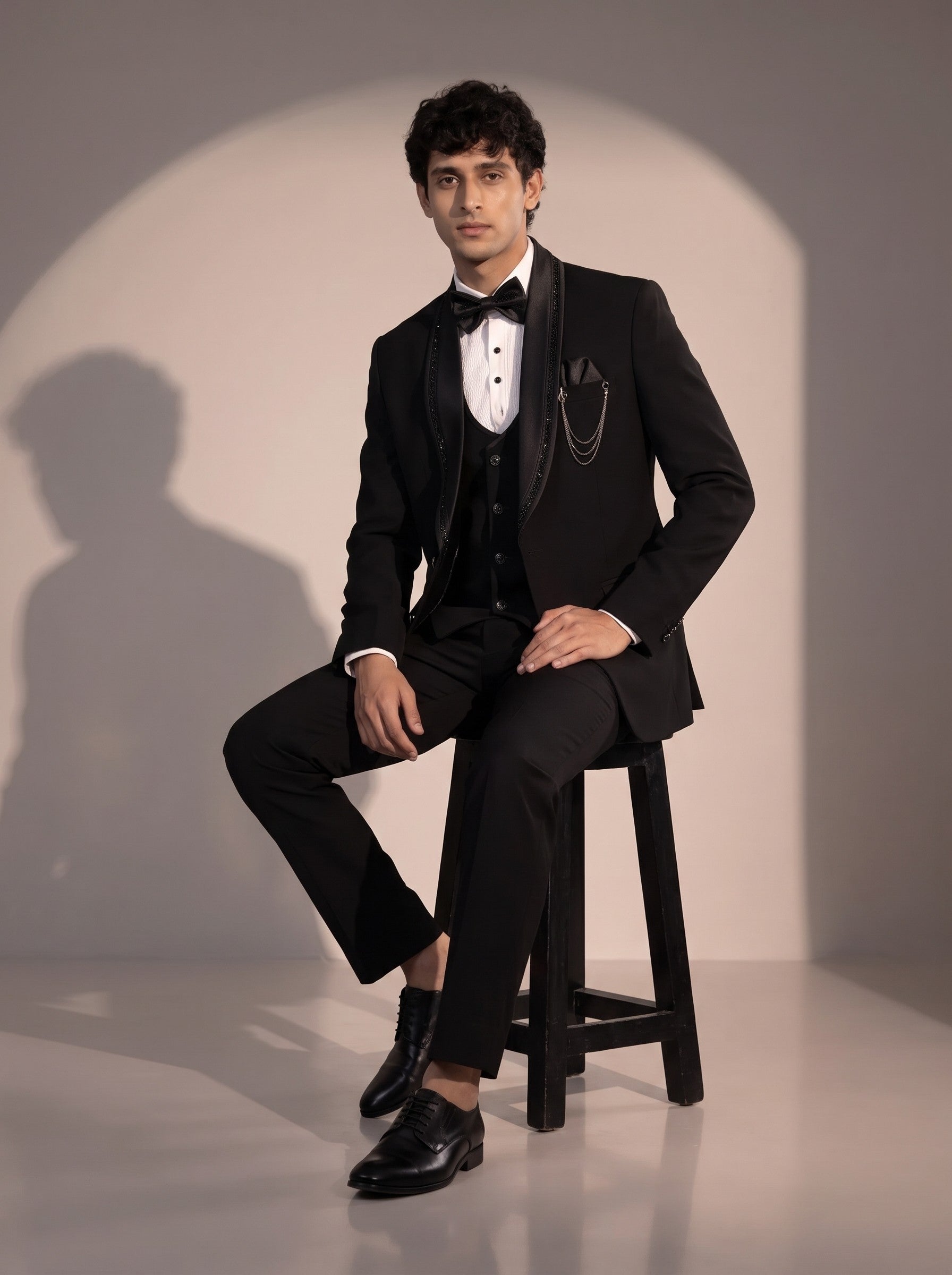 Black crystal trim tuxedo suit for men - seated pose