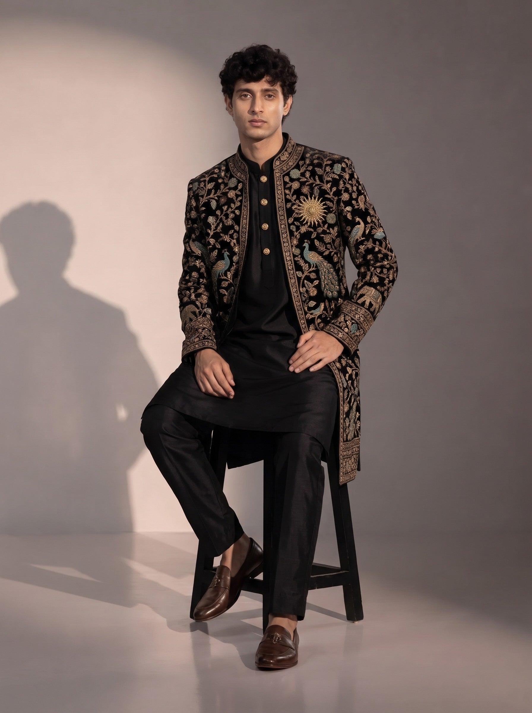 Black peacock embroidered silk indowestern for men - seated pose