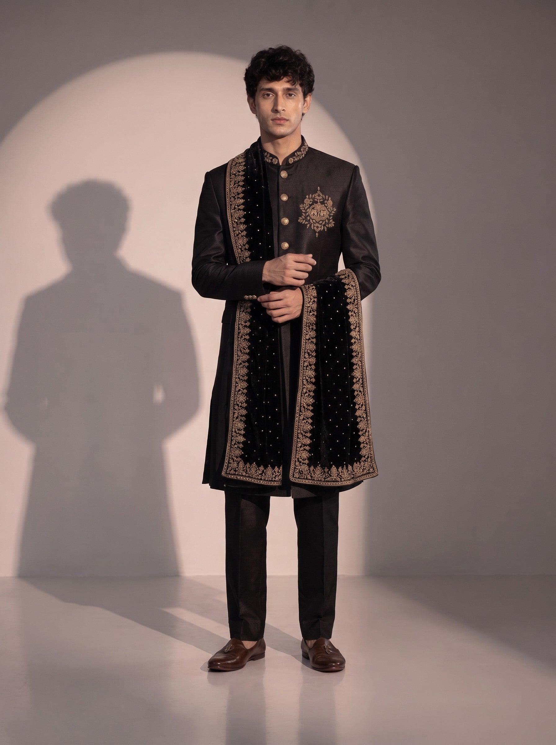 Black silk indowestern for men with velvet stole - three-quarter view showing gold crest