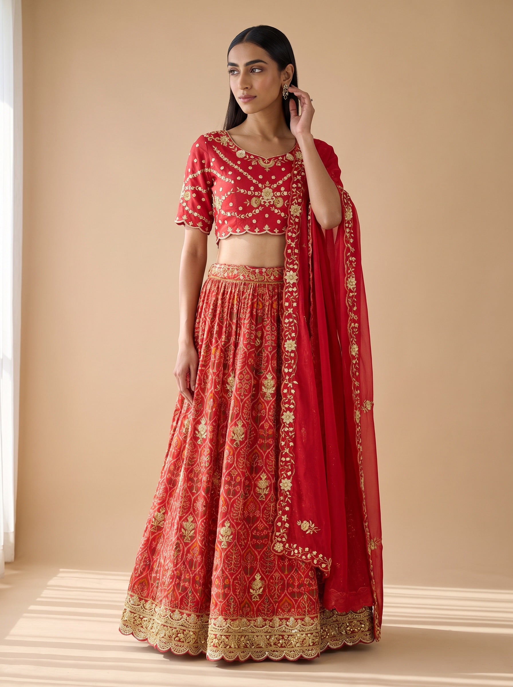 Red silk lehenga set styled with a matching embroidered dupatta, front three-quarter view