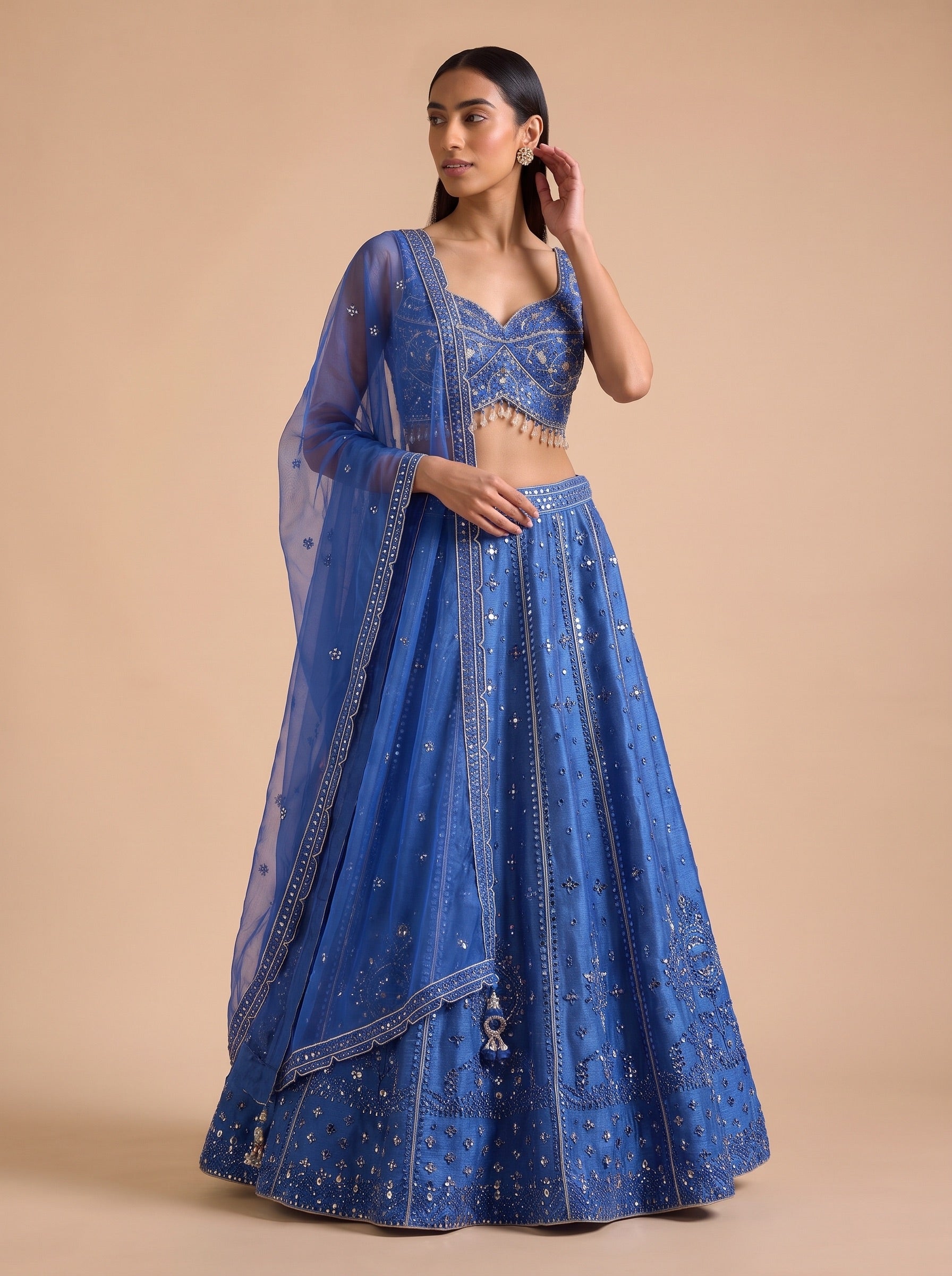 Royal Blue silk lehenga with embellished blouse and dupatta, casual standing pose