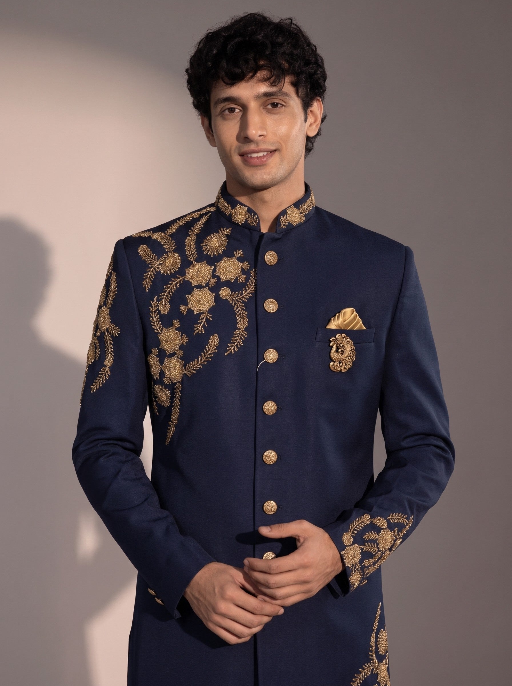 Navy blue indowestern close-up showing gold zardozi embroidery, collar, buttons and peacock brooch